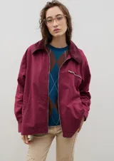 Campera de jean azul oscuro con cuello de pana en color crema. Presenta cierre frontal metálico, bolsillo con cierre en el pecho y bolsillos laterales. Diseño de corte holgado con mangas largas.