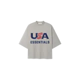 Remera oversize gris claro de manga corta con cuello redondo y estampa frontal de estilo universitario con las inscripciones "USA" y "ESSENTIALS".