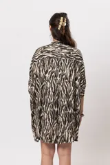 Camisa de corte oversize, con diseño estampado animal print de cebra, mangas cortas amplias y cierre frontal con botones.