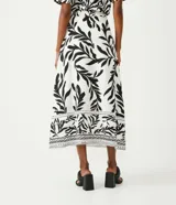 Pollera midi color blanco con estampado de hojas negras, cintura alta y corte recto.