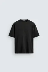Camiseta de corte relajado confeccionada en algodón con textura irregular, cuello redondo y manga corta.