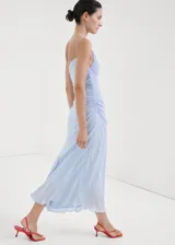 Vestido midi color celeste con diseño evasé, cuello asimétrico de un solo hombro con tirante fino, cuerpo fruncido y cierre de cremallera lateral.