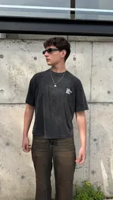 Remera negra con efecto gastado y estampado en la espalda con la frase 'f*ck nudes. send me your playlist.' en letras blancas.