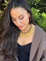 Collar corto con cuentas de cerámica negras y blancas, pinchos de piedra reconstituida amarillos, cristales checos y mostacillas. Se cierra con cadena de acero quirúrgico para regular el largo.