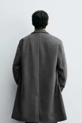 Abrigo de corte regular fit confeccionado en tejido compacto con mezcla de lana. Presenta cuello con solapas de muesca, cierre frontal de botonadura, bolsillos de vivo en la cadera y abertura central en la espalda.