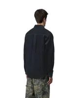 Camisa de manga larga Carhartt modelo Flint, confeccionada en pana de algodón color blanco. Presenta cuello clásico, cierre frontal con botones y un bolsillo en el pecho con el logo de la marca bordado.