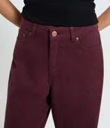 Pantalón baggy de sarga color bordó, con cintura tradicional, cierre de botón y cremallera, bolsillos curvos y corte recto y holgado.