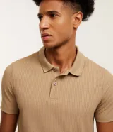 Remera polo slim color tostado, con textura acanalada, manga corta y cierre frontal de botones.
