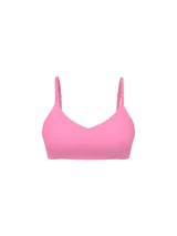 Sujetador inalámbrico ligeramente forrado de color rosado, con escote pronunciado, tirantes ajustables con logo y microfibra suave.