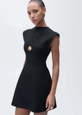 Vestido corto negro con cuello perkins y diseño sin mangas. Presenta un corte entallado en la parte superior con hombros estructurados y una falda con ligero vuelo.