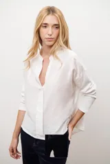 Blusa de color azul oscuro, con cuello mao y escote en V. Presenta mangas largas con puños abotonados y un corte recto y holgado.