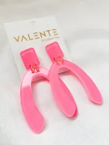 Aros colgantes de acrílico color rosa neón, con forma geométrica abstracta.