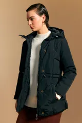 Campera puffer beige con capucha desmontable, cordón ajustable en la cintura, bolsillos laterales y cierre frontal con botones y cremallera.