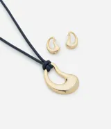 Conjunto de collar con cordón ajustable y colgante orgánico dorado, acompañado de caravanas orgánicas doradas. El colgante tiene forma de gota y los aros son pequeños con la misma forma. El collar tiene un cordón azul marino.