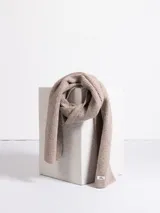 Bufanda de tejido de punto acanalado en color beige, con etiqueta de marca en uno de sus extremos.