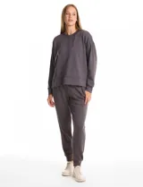 Buzo deportivo de cuello redondo, con hombros caídos y mangas largas con puños. Presenta costuras decorativas tipo pespunte en la parte frontal y en las mangas, con un diseño de ruedo recto y tajos laterales.