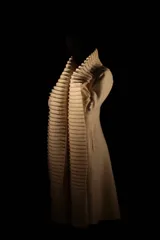 Tapado largo color crudo, confeccionado en lana merino afieltrada. Presenta cuello alto y guarda tejida en el cuello y ruedo. Tiene un estampado de una luna en la espalda.