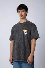 Remera de algodón con efecto acid wash en color gris oscuro. Presenta un diseño estampado en el pecho con una estrella amarilla y un personaje animado, y un corte semi-oversize.