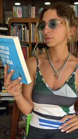 Collar de mostacillas de acrílico color turquesa con un dije colgante en forma de cuerno italiano (cornicello) rojo con incrustaciones de piedras turquesas. El engarce del dije y las cuentas separadoras son de metal dorado.