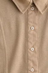 Remera polo de manga larga confeccionada en punto de algodón, con cuello clásico, tapeta frontal con botones y costuras moldeadoras en el frente.