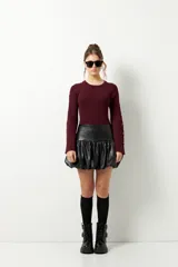 Minifalda negra de cuero sintético con cintura alta y corte globo.