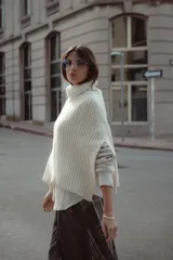 Poncho tejido de lana con cuello alto y diseño de calce relajado, ideal para capas de abrigo.
