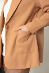 Blazer color camel de paño, corte recto, con solapas y cierre frontal con un botón.