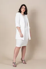 Vestido blanco con bordado de perlas y canutillos en el escote y túnica larga con tajos y ribete de satén.