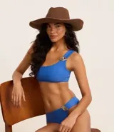 Sombrero de playa de ala mediana confeccionado en fibra de papel, con detalle de abalorios de madera en la base de la copa.