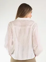 Blusa negra de broderie, con mangas largas abullonadas y cierre frontal de botones.