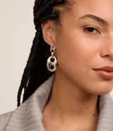 Aros colgantes dorados con forma de eslabones unidos por un aro contrastante.