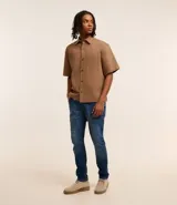 Pantalón de jean skinny azul con cierre de botón y cremallera, bolsillos y sin estampado.