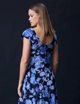Vestido midi de gasa con estampado floral azul sobre fondo negro, torso drapeado y forro interno a tono.