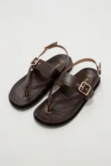 Sandalias negras de eco cuero estilo chunky, con diseño de tiras cruzadas y hebilla metálica dorada en la parte superior. Cuenta con tira ajustable en el talón.