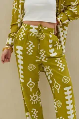 Pantalón color verde lima con estampado abstracto en blanco, de corte recto y tiro alto con cordón ajustable en la cintura.