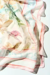 Pañuelo cuadrado grande con diseño estampado de paisaje tropical, palmeras, tortugas marinas y detalles marinos, con bordes en tonos rosados y celestes.