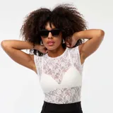 Camiseta blanca de encaje con calados, sin mangas y cuello redondo.