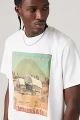Remera blanca de algodón con estampa frontal de carros cubiertos y el texto "all over the west they wear" y "Levi Strauss & Co.".