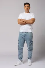Pantalón jean celeste, corte jogger, con bolsillos cargo laterales y puños elásticos en los tobillos.