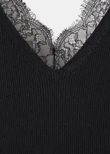 Vestido midi negro confeccionado en tejido de punto acanalado, con tirantes finos, escote en V y detalles de encaje en el escote y en el bajo asimétrico.