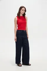 Pantalón jean azul oscuro, de tiro alto y corte ancho, con bolsillos y pespuntes en tono contrastante.