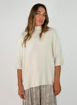 Sweater de punto color beige con cuello alto, diseño holgado y mangas cortas con puños acanalados.