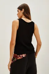 Top de punto color beige, con escote en U pronunciado y textura sedosa y brillante.