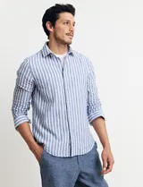 Camisa de lino a rayas verticales color beige y blanco, de corte clásico, con cuello abotonado y mangas largas.