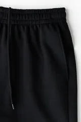 Short de felpa liviana de algodón color negro, con cintura elástica, bolsillos laterales y corte estándar.