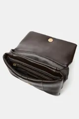 Mini bandolera de efecto acolchado en color marrón oscuro, con diseño de pespuntes verticales. Cuenta con una cadena dorada que funciona como asa de hombro o bandolera, cierre de solapa con botón imantado y doble compartimento interior con bolsillo con cremallera.