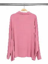 Camisa de corte relajado y diseño holgado, con mangas largas tipo murciélago y cierre frontal de botones. Presenta cuello clásico y un acabado fluido.