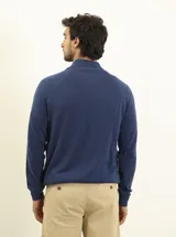 Cardigan azul de tejido de punto con cierre frontal, cuello alto y bolsillos laterales.