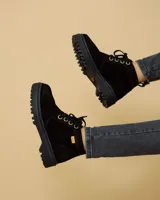 Bota de cuero color negro, con cordones y suela track.