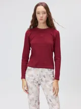 Remera de manga larga y corte clásico con cuello redondo, de color negro con costuras en hilo rojo a contraste y logo bordado en el centro del pecho.